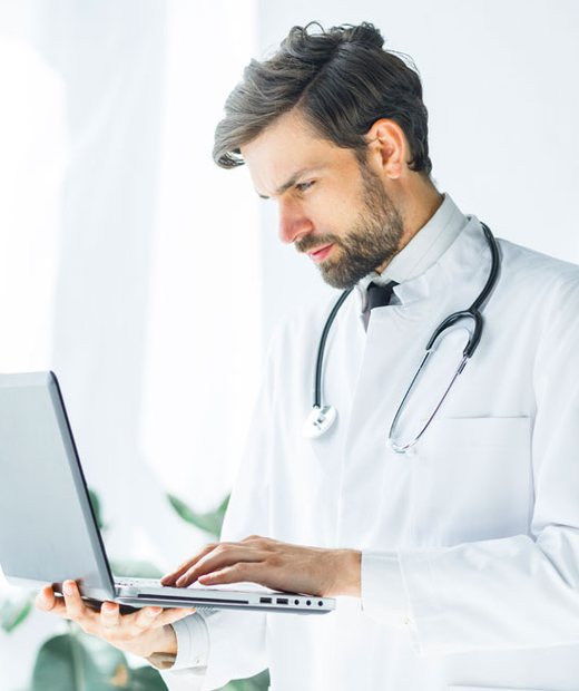 Doctor reviewing notes on a laptop