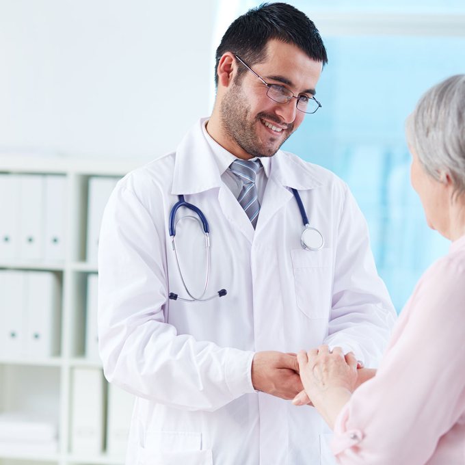 Doctor gently holding the hands of an older patient at Health Holistic Core